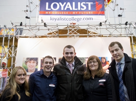 Loyalist College student ambassadors Bev LeClair and Stephen Silas, Belleville Bulls' Michael Curtis, Loyalist recruitment's Irene Cooke and Bulls' Brent Larmer pose at the Loyalist College booth on Loyalist College Night at the Yardmen Arena.